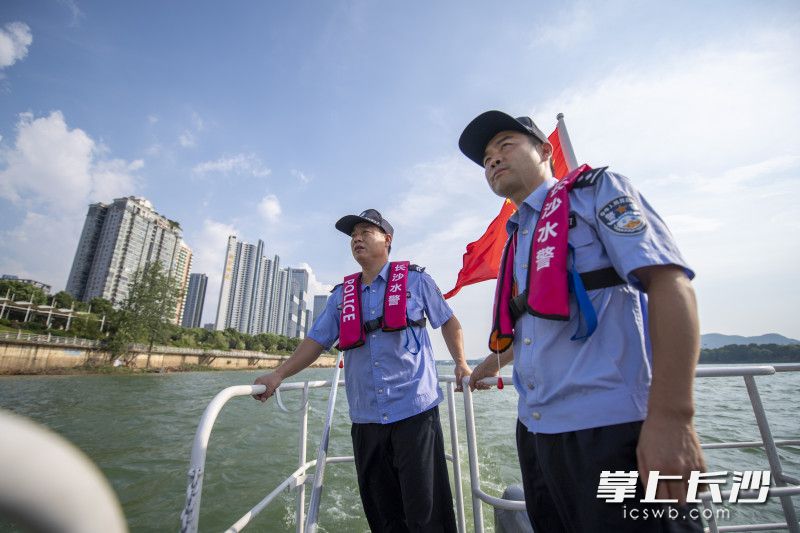 水警郑苗（右）和协警谢义乘坐巡逻艇对湘江水域进行巡查。