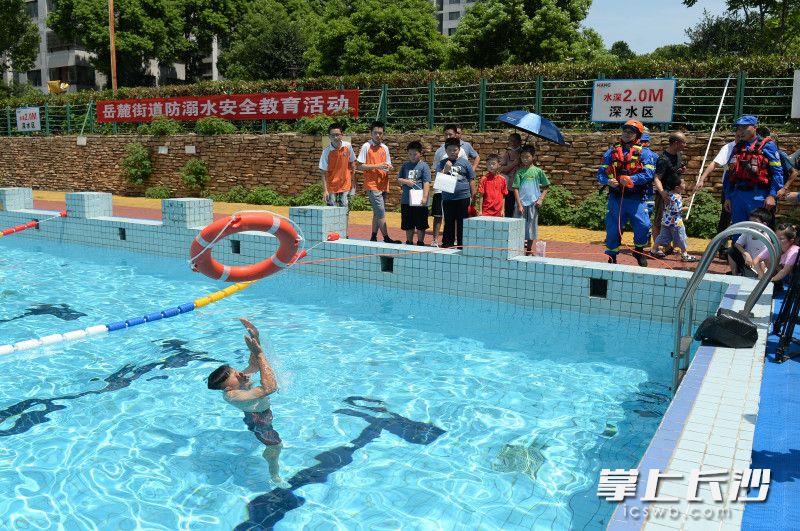 长沙县蓝天救援服务中心救援队员在一家户外游泳场馆进行室外实践教学。
