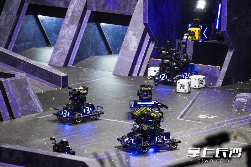 比赛中，蓝方湖北工业大学”力创RM战队“的“英雄”“步兵”“哨兵”“工程”机器人聚集在一起准备向对方发起进攻。 