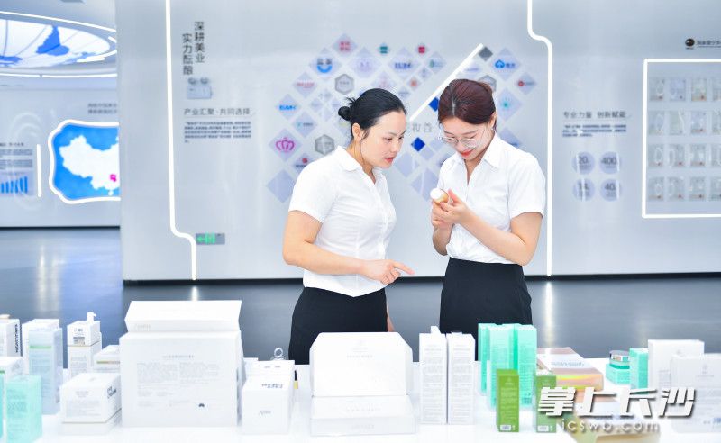 两位女士正在美妆谷展厅了解企业生产的美妆产品。