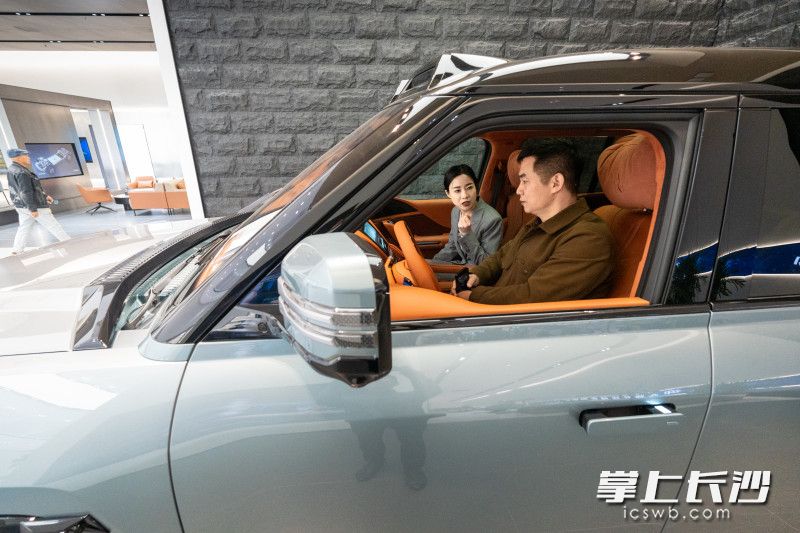 比亚迪高端品牌仰望湖南首家中心开业，现场市民正在了解车辆性能。