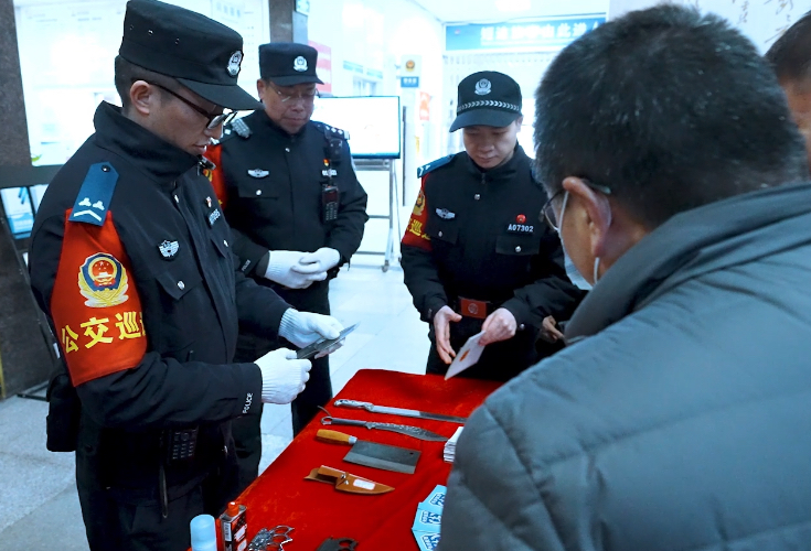 民警摆放查获的相关违禁物品，向过往乘客普及相关知识。