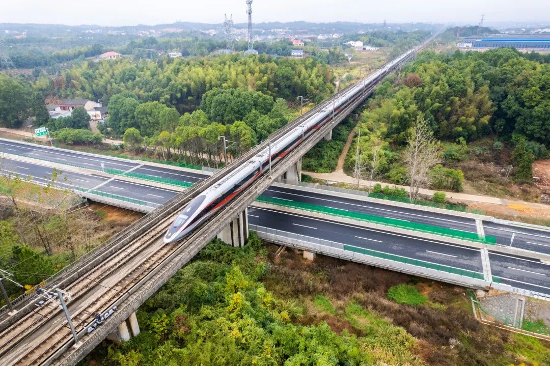 高铁列车从湖南省首条智慧高速——湖南平江（湘赣界）至益阳高速公路上方驶过。新华社记者 陈思汗 摄