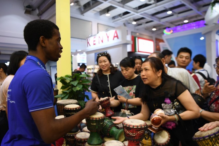 The file photo shows a staff member from the Republic of Ghana introducing hand drums to visitors during the China-Africa Economic and Trade Expo in Changsha, central China's Hunan Province, on June 28, 2019. (Xinhua/Xue Yuge)