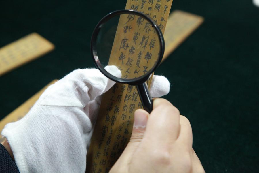 This file photo taken on Dec. 20, 2017 shows Zhang Chunlong, a researcher at the Hunan Provincial Institute of Cultural Relics and Archaeology and one of the excavators of the Liye Qin Slips, identifying one of such slips unearthed from the Liye ancient town in Longshan County, Xiangxi Tujia and Miao Autonomous Prefecture, central China's Hunan Province. (Hunan Provincial Institute of Cultural Relics and Archaeology/Handout via Xinhua)