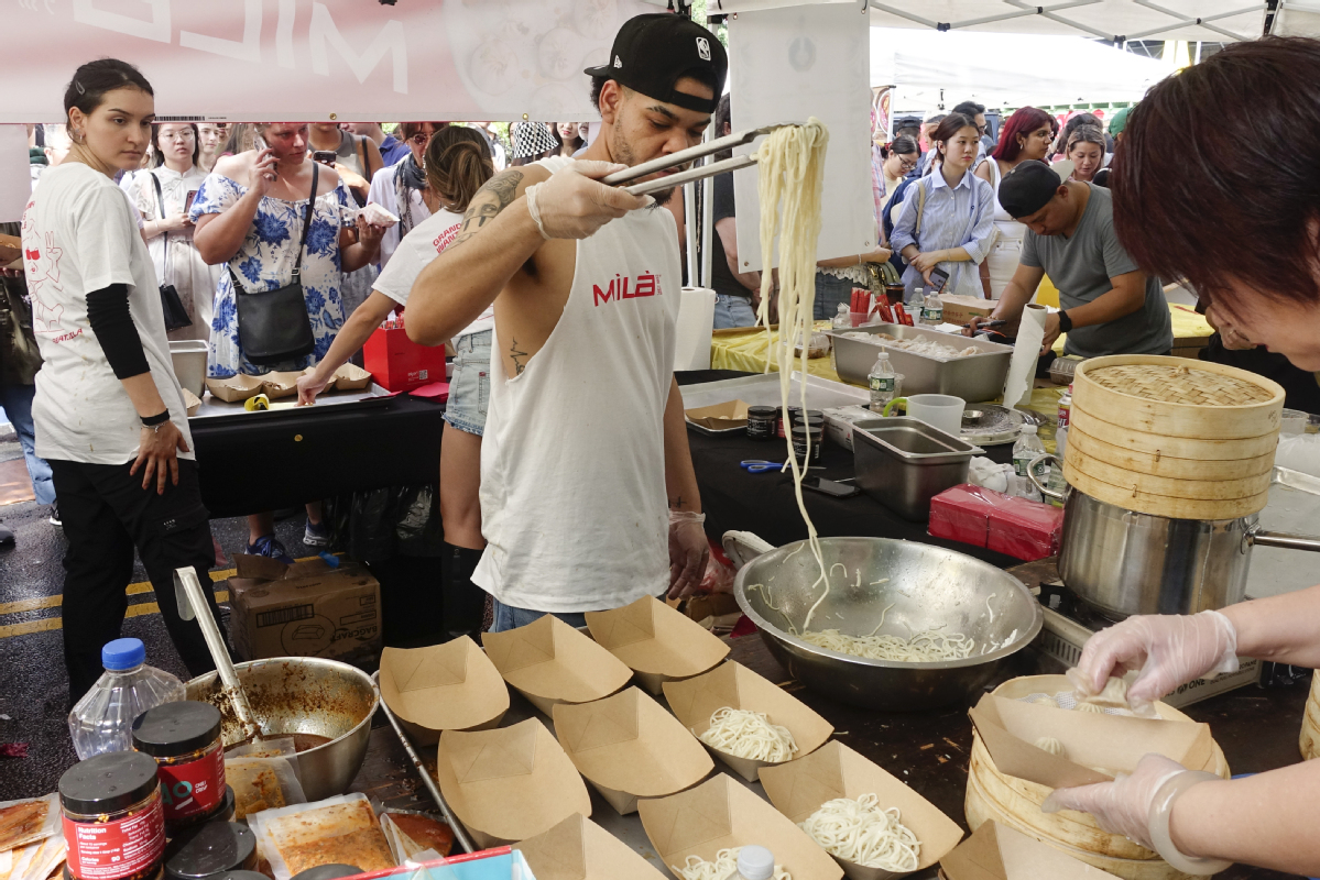 A cook prepares Chinese noodles at a food market in New York in June 2023. LIAO PAN/CHINA NEWS SERVICE